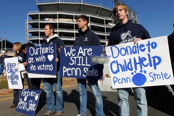 People holding posters outside of Beaver Stadium